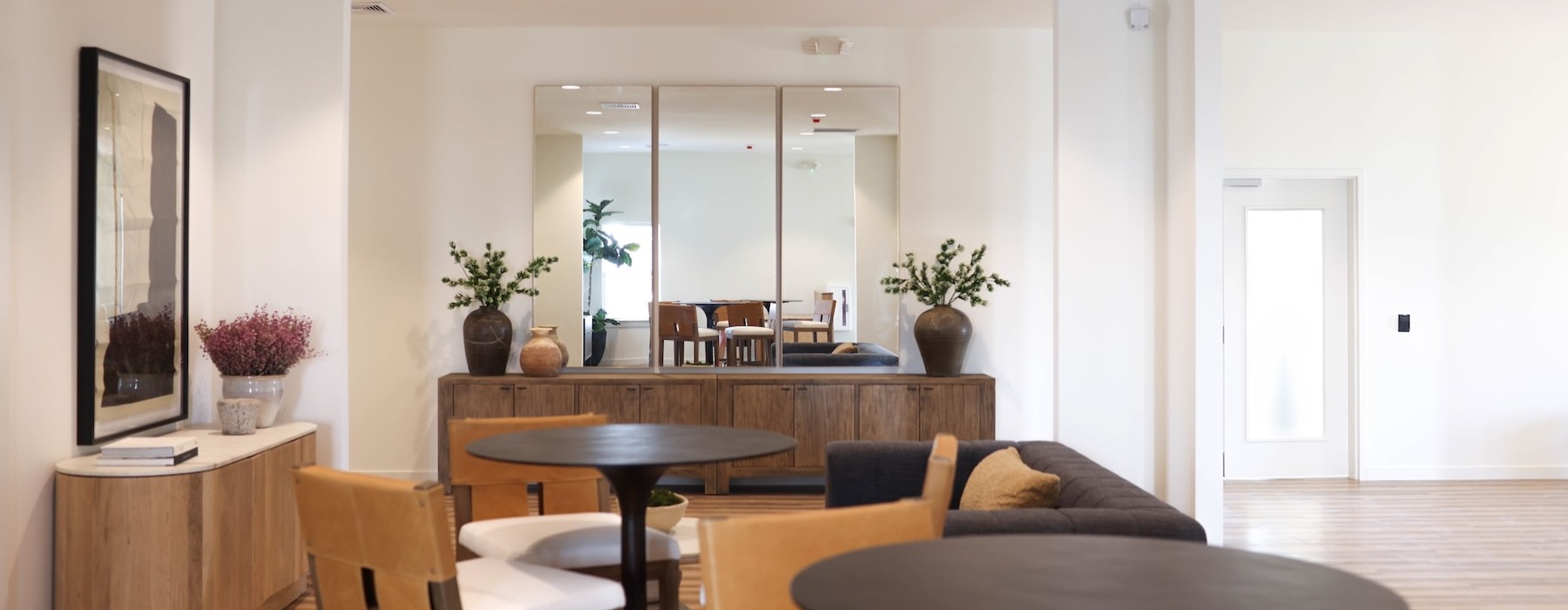 a clubroom with a couch, tables and chairs